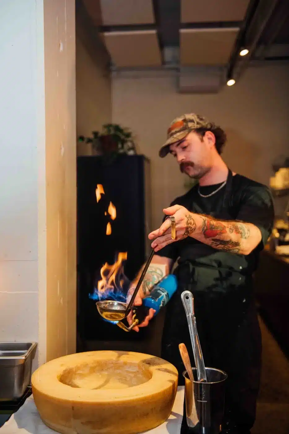 Chef qui flambe une meule de parmesan pour les pâtes lors d'un événement privé à Montréal